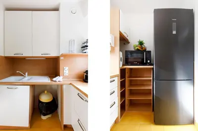 a kitchen with white cabinets and a stainless steel refrigerator at Les Liserons YourHostHelper in Cannes