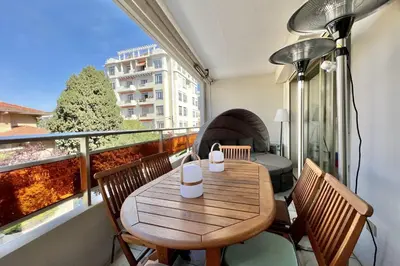 a small balcony with a wooden table and chairs at Beautiful flat with terrace near Croisette in Cannes