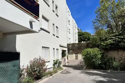 a white building with a fence next to a street at Beautiful flat with terrace near Croisette in Cannes