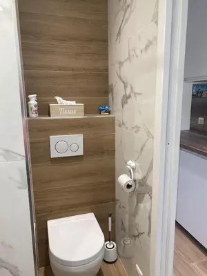a bathroom with a white toilet and marble walls at Studio CANNES PARC CROISETTE in Cannes