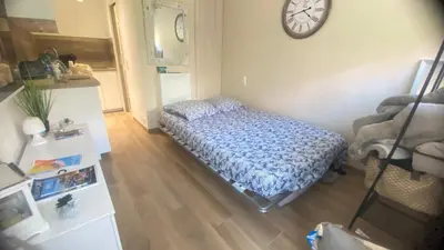 a bedroom with a bed and a clock on the wall at Studio CANNES PARC CROISETTE in Cannes