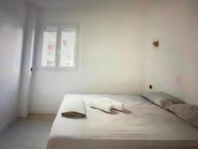 a white bedroom with a bed with a window at Appartement Avec Terrasse Centre-ville Croisette in Cannes