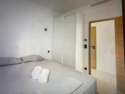 a white bedroom with two towels on a bed at Appartement Avec Terrasse Centre-ville Croisette in Cannes