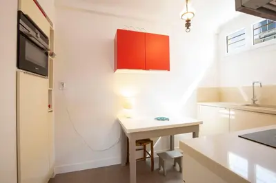 a kitchen with a small table and a red cabinet at WE CANNES ! Cosy 2-bedroom apartment with terrace Cannes Center in Cannes