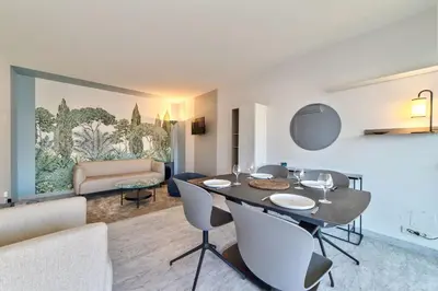 a living room with a table and chairs and a couch at Appartement Canto bright appartement Croisette beach in Cannes
