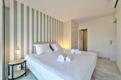 a bedroom with a white bed with towels on it at Appartement Canto bright appartement Croisette beach in Cannes