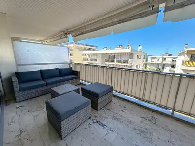 a couch and ottoman on a balcony at Appartement Canto bright appartement Croisette beach in Cannes