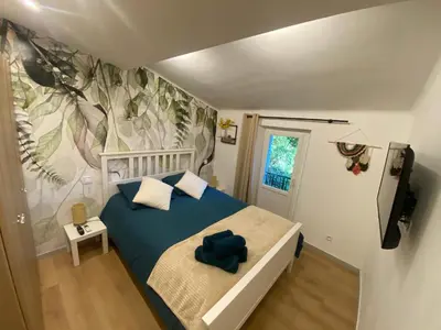 a bedroom with a bed with a blue blanket at Appartement rénové Cannes Suquet in Cannes