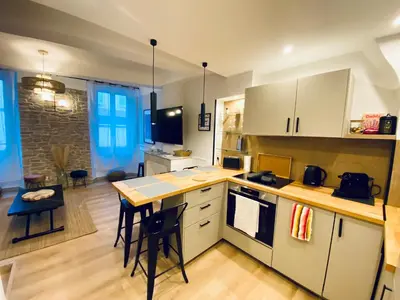 a kitchen with white cabinets and a table and chairs at Appartement rénové Cannes Suquet in Cannes