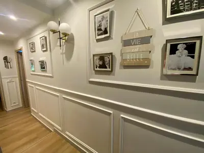 a hallway with a white wall with pictures on it at Appartement rénové Cannes Suquet in Cannes