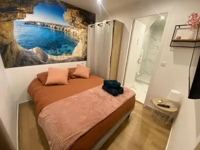 a bedroom with a bed with a painting on the wall at Appartement rénové Cannes Suquet in Cannes