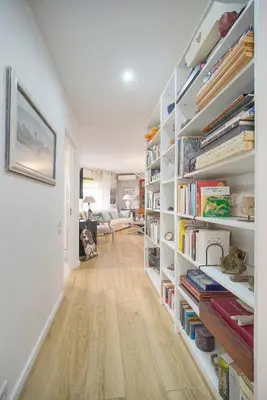 a room with white shelves filled with books at FRGK 