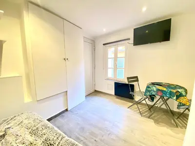 a living room with a table and a tv on the wall at Mini Studio - Le Panisse By SCLS Locations in Cannes