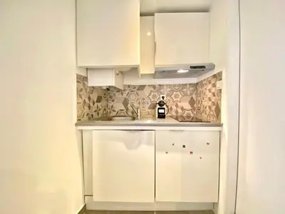 a kitchen with white cabinets and a sink at Mini Studio - Le Panisse By SCLS Locations in Cannes