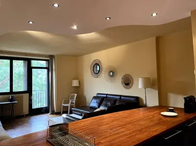 a living room with a couch and a wooden table at Cannes Montfleury grand confort in Cannes
