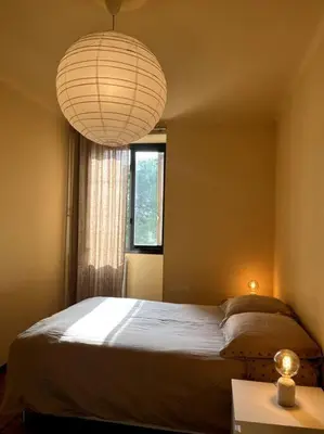 a bedroom with a bed and a window and a lamp at Cannes Montfleury grand confort in Cannes