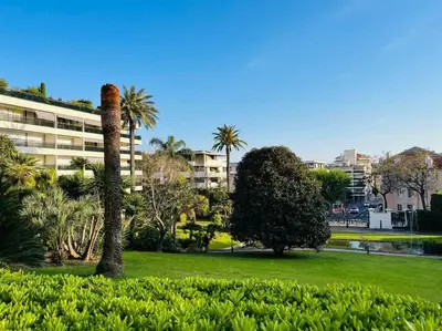 a palm tree in a park next to a building at Cannes Montfleury grand confort in Cannes
