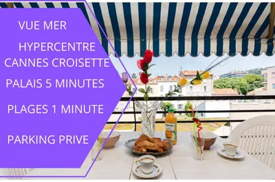 a table with a vase of flowers on a balcony at Perle Rare Cannes Croisette Vue Mer Parking 4P in Cannes