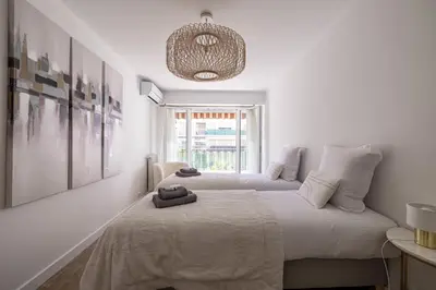 two beds in a white room with a window at Magnificent 3room apartment quiet balcony in Cannes