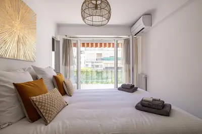 a bedroom with a large white bed with a large window at Magnificent 3room apartment quiet balcony in Cannes