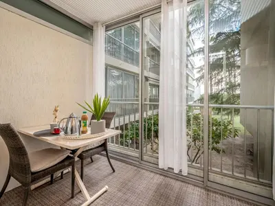 a room with a table and chairs and a large window at Apartment Les Sablons-2 by Interhome in Cannes