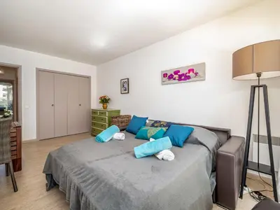 a bedroom with a large bed with blue pillows at Apartment Les Sablons-2 by Interhome in Cannes