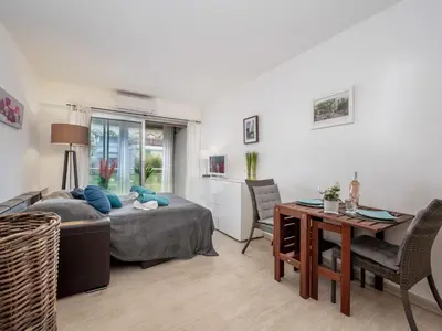 a living room with a bed and a table at Apartment Les Sablons-2 by Interhome in Cannes