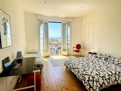 a bedroom with a bed and a view of a balcony at SUPERBE 2 TERRASSES VUE MER in Cannes