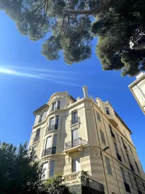 a tall white building with trees in front of it at SUPERBE 2 TERRASSES VUE MER in Cannes