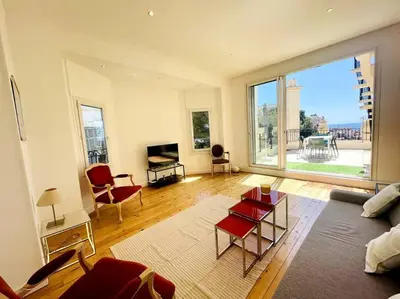 a living room with a couch and a large window at SUPERBE 2 TERRASSES VUE MER in Cannes
