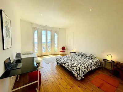 a bedroom with a bed and a desk in it at SUPERBE 2 TERRASSES VUE MER in Cannes