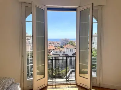 a room with two glass doors to a balcony at SUPERBE 2 TERRASSES VUE MER in Cannes