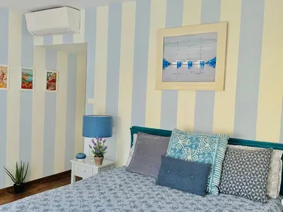 a bedroom with a bed with blue and white stripes at Luxury&Privacy - Pool, Parking, AC - Palais in 5' in Cannes