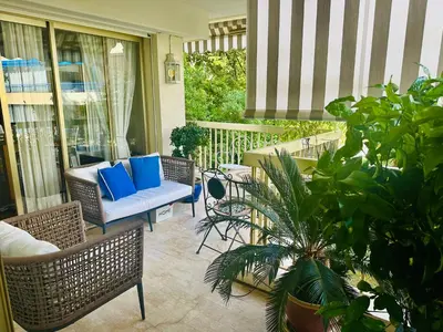 a porch with blue pillows and chairs and plants at Luxury&Privacy - Pool, Parking, AC - Palais in 5' in Cannes