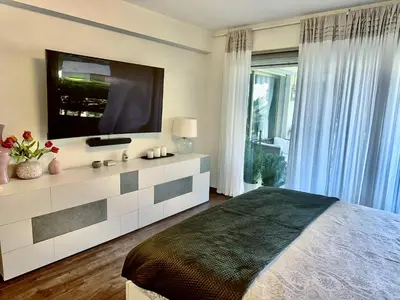 a bedroom with a large bed with a flat screen tv at Luxury&Privacy - Pool, Parking, AC - Palais in 5' in Cannes
