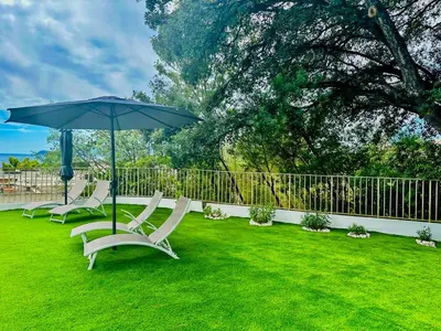 a group of chairs and an umbrella on a lawn at Luxury&Privacy - Pool, Parking, AC - Palais in 5' in Cannes