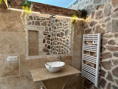 a bathroom with a sink and a stone wall at Villa Paradis - Cannes in Cannes