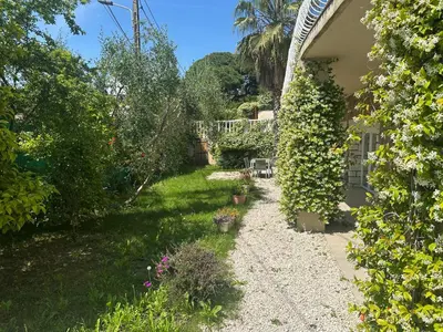 a garden next to a house with plants at Villa Paradis - Cannes in Cannes