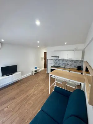 a living room with a blue couch and a table at Joli Appartement 2 pieces Cannes in Cannes