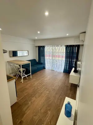 a living room with a blue couch and a table at Joli Appartement 2 pieces Cannes in Cannes