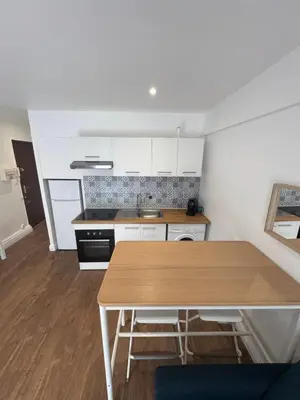 a kitchen with a wooden table in a room at Joli Appartement 2 pieces Cannes in Cannes