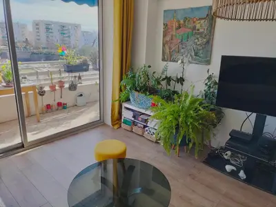 a living room with a glass table and some plants at Le Vallombrosa - Deux pièces lumineux et confortable in Cannes