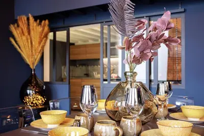 a table with a glass vase with flowers in it at Le Splendide by Connexion in Cannes