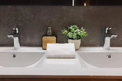 a bathroom with two sinks with a bottle of soap at Le Splendide by Connexion in Cannes