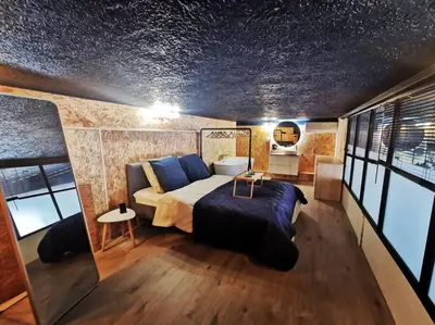 a bedroom with a bed in a room with windows at Le Splendide by Connexion in Cannes