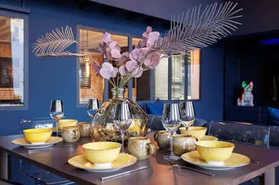 a table with a vase with pink flowers in it at Le Splendide by Connexion in Cannes