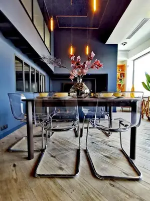 a dining room table with chairs and a vase with flowers at Le Splendide by Connexion in Cannes