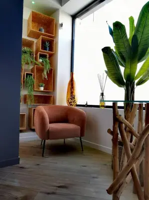 a room with a chair and a potted plant at Le Splendide by Connexion in Cannes