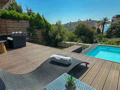 a deck with a chair and a swimming pool at Piscine privée, Plages à pied & Palais à proximité in Cannes