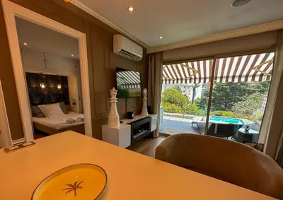 a room with a table and a bedroom with a bed at Piscine privée, Plages à pied & Palais à proximité in Cannes